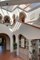 Um interior espaçoso com teto alto, nichos em arco e uma vitrine de vidro com sapatos.