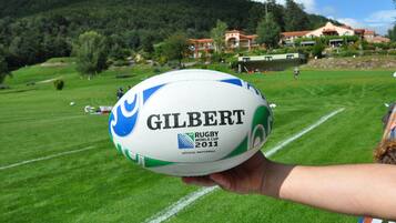 A rugby ball with "Gilbert" and "Rugby World Cup 2011" text, held by a person.