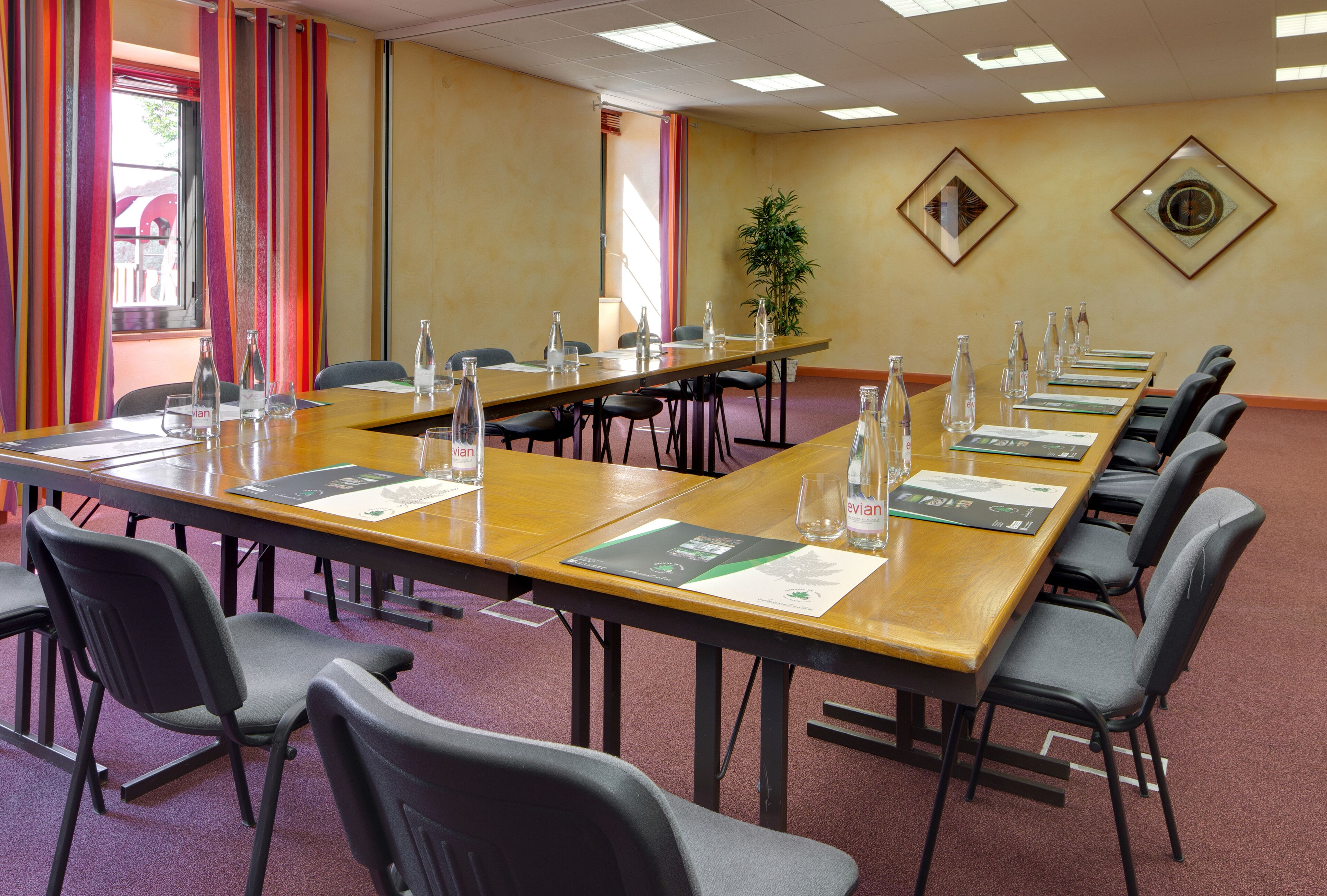 A conference room with a long table, chairs, water bottles, and name cards.