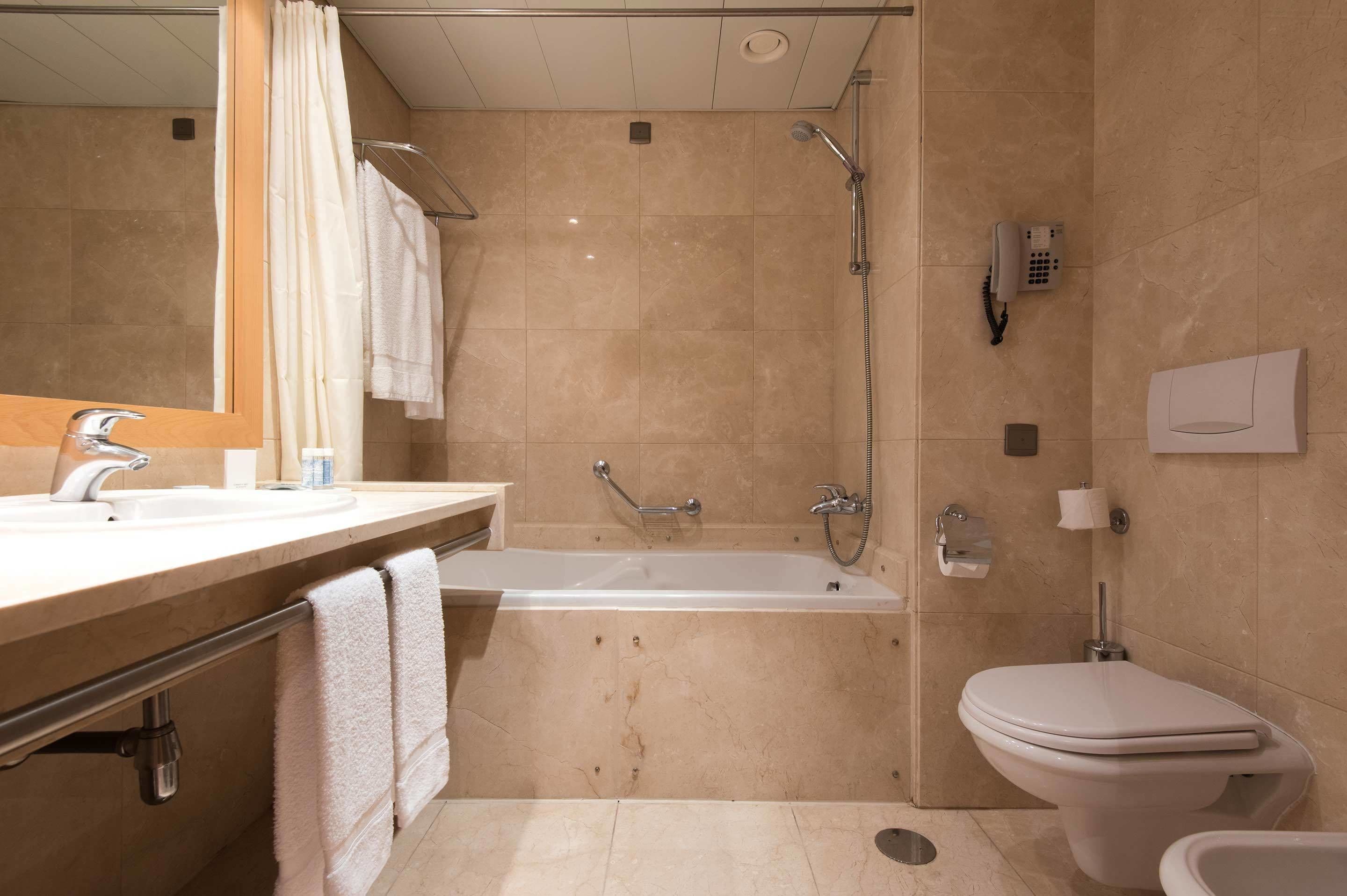 Une salle de bain moderne équipée d’une baignoire, de toilettes et d’une douche.