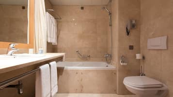 Une salle de bain moderne équipée d’une baignoire, de toilettes et d’une douche.