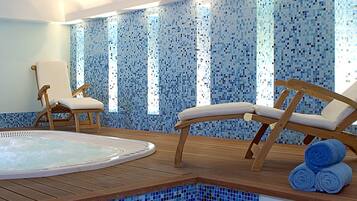 Relax by the pool with a hot tub and lounge chairs on the deck, surrounded by blue mosaic tiles and natural light.
