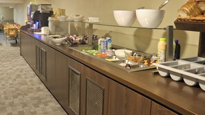 A buffet setup with various food items, a coffee machine, and a breakfast bar. - XO Hotels Infinity (Amsterdam)