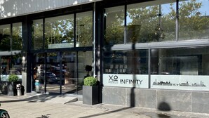 A modern hotel building with large windows, a visible entrance, and a sign reading "X.O Hotels Infinity". - XO Hotels Infinity (Amsterdam)