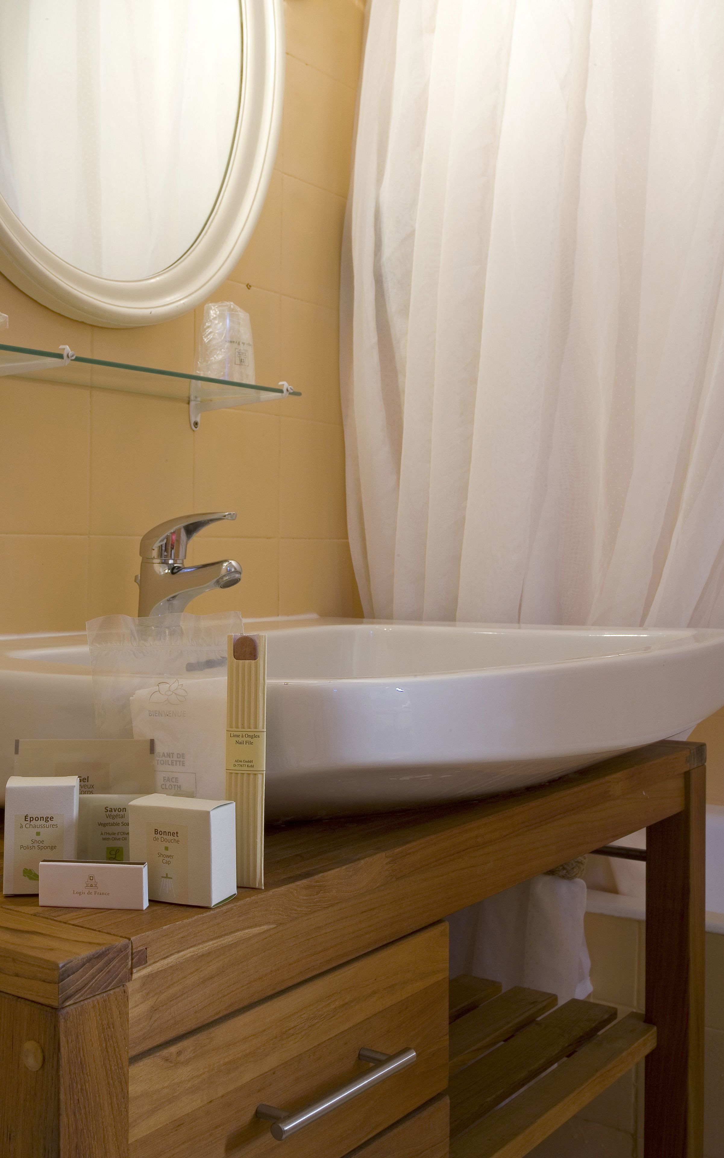 A bathroom with a white sink, a mirror, and a wooden vanity with drawers.