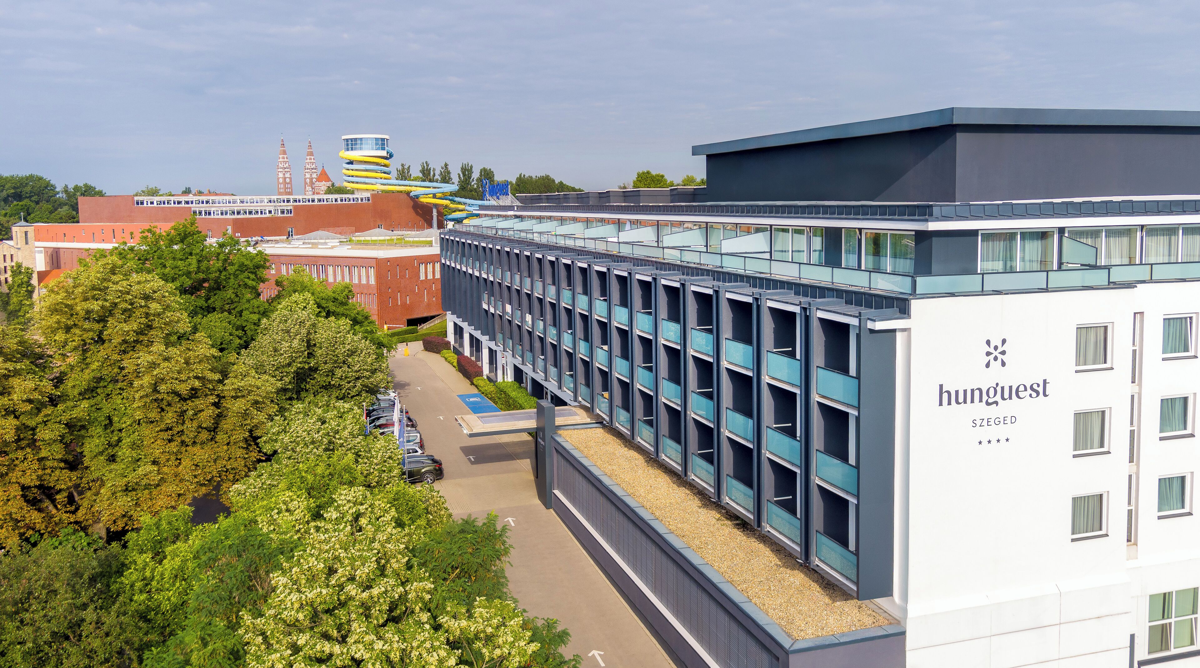 Un edificio moderno con fachada de vidrio, con la leyenda "hunguest SZEGED".