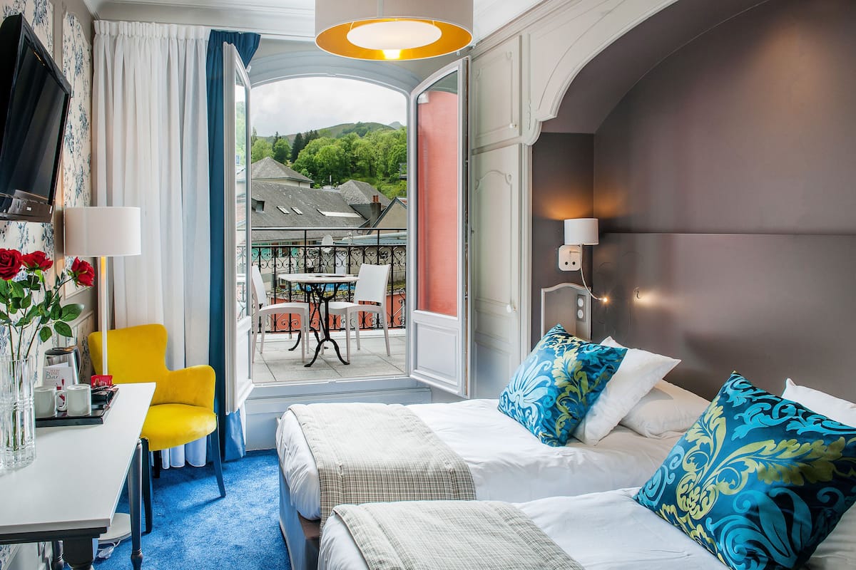 Ein Hotelzimmer mit Bett, Schreibtisch, Stuhl und Blick nach draußen.