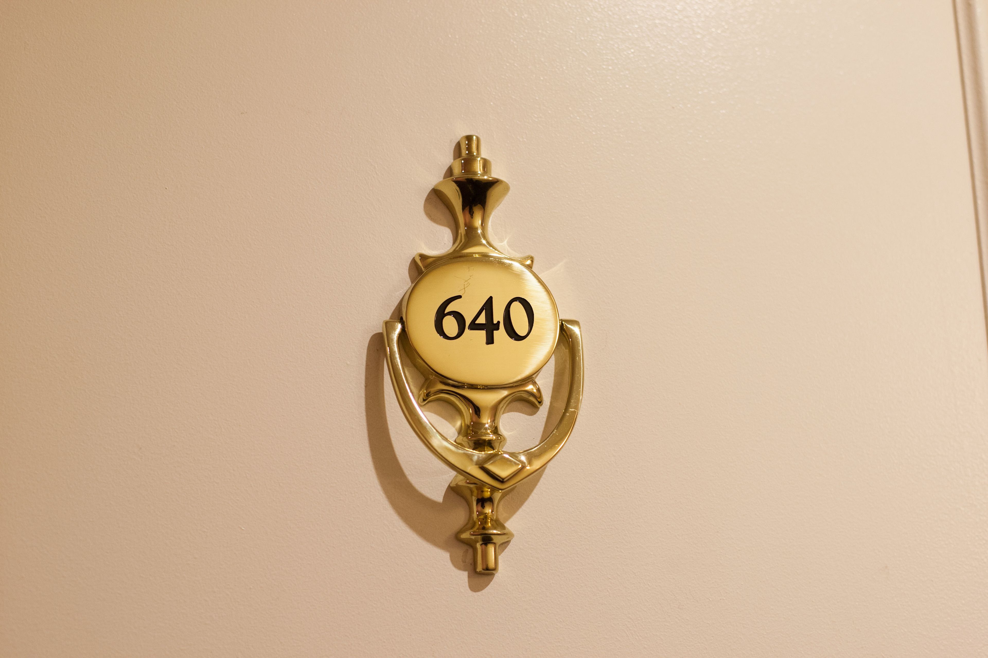 A brass doorbell with the number 640.