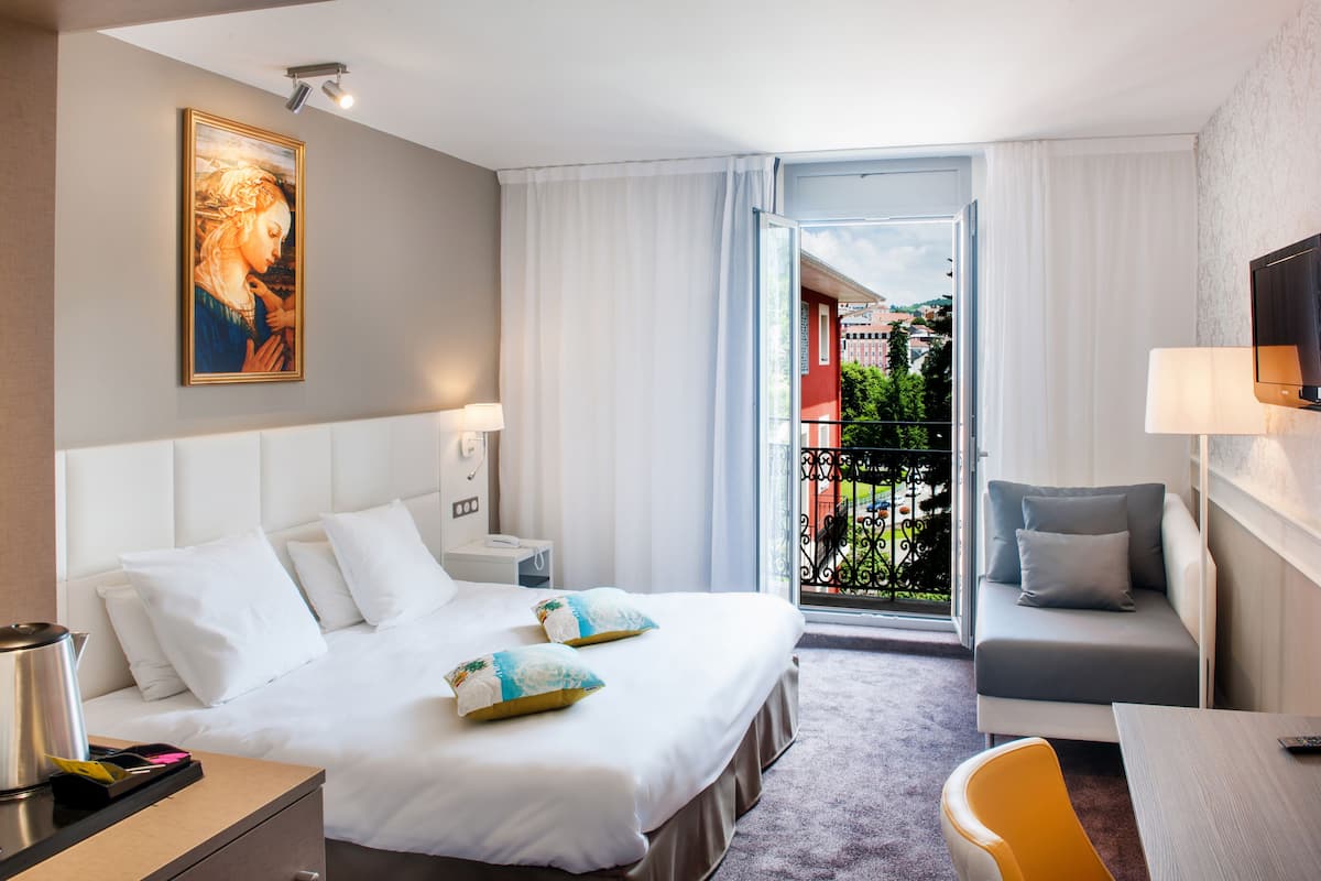 Ein Hotelzimmer mit Bett, Nachttisch und Sofa.