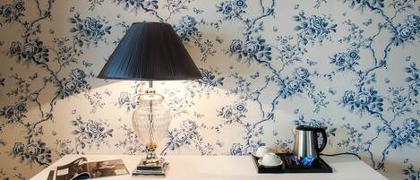 Une table avec une lampe, une bouilloire et un plateau contenant des tasses et une théière.