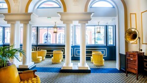 A grand lobby with high ceilings, arched windows, and a patterned floor. - Grand Hotel Gallia & Londres (Lourdes)