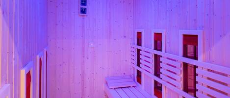A sauna with wooden walls and benches, featuring skylights and a control panel.