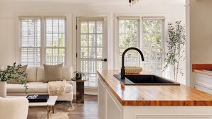 A modern kitchen with a wooden countertop, a black sink, and a pendant light. - EHP Resort & Marina (East Hampton)