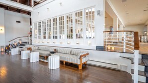 A spacious lobby with a large seating area, a staircase, and a view of the upper floor. - EHP Resort & Marina (East Hampton)