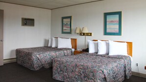 A hotel room with two beds, a nightstand, a lamp, and a painting on the wall. - Budget Host Crestview Inn (Sault Ste. Marie)