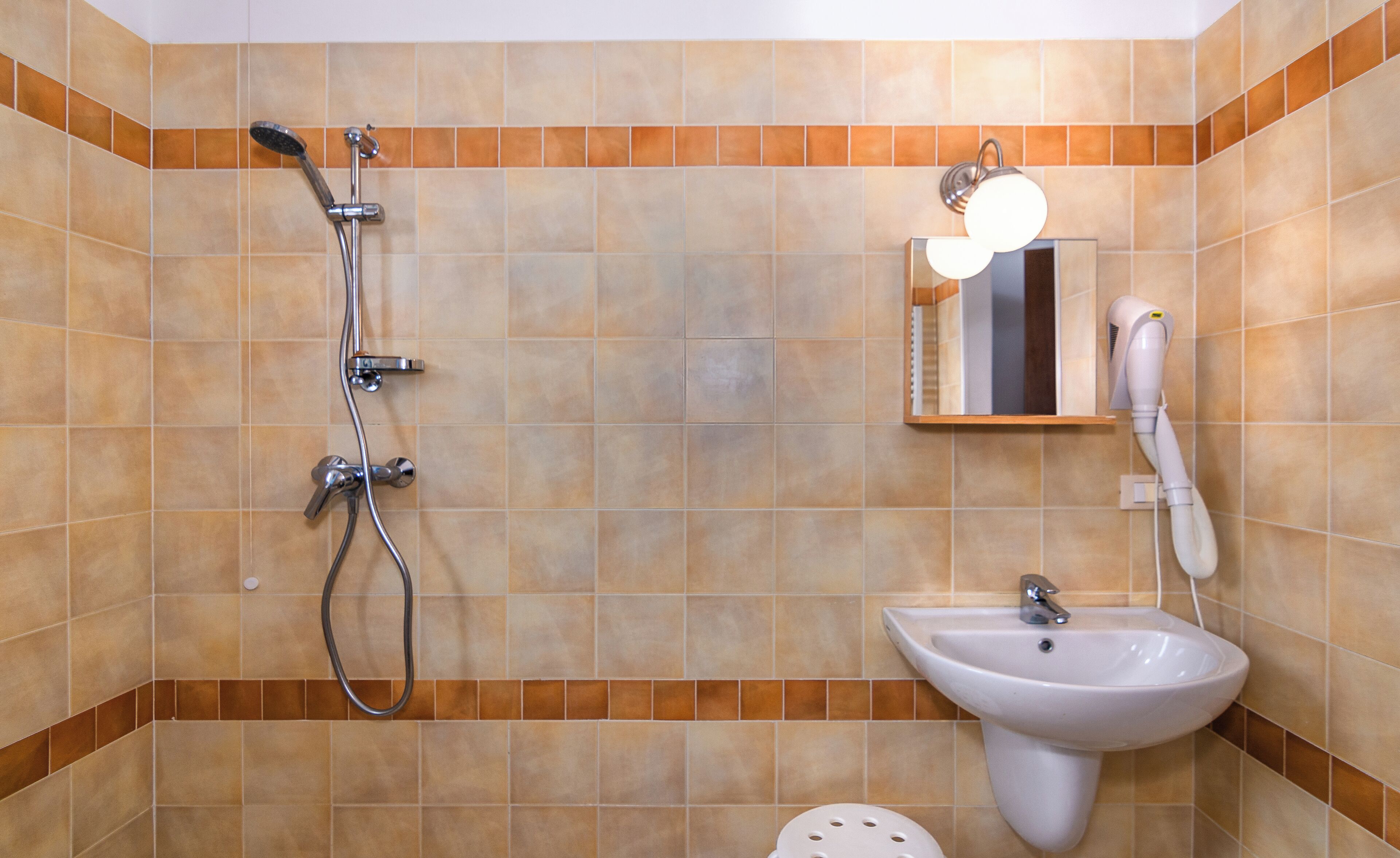 Une salle de bain avec une douche, un lavabo et un miroir.