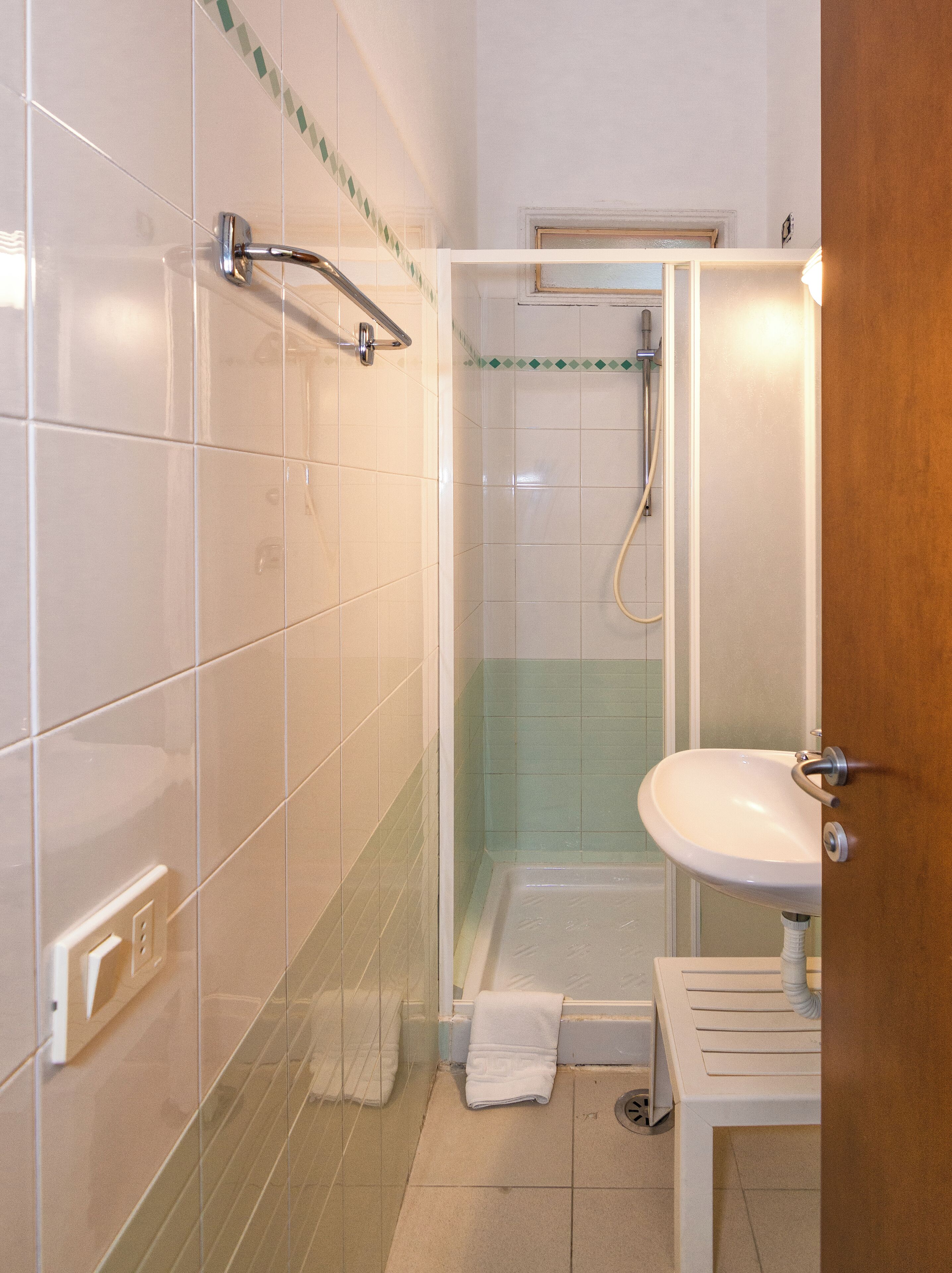 A bathroom with a shower, a sink, and a toilet.