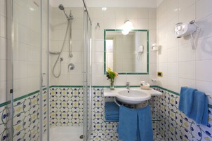 Ein Badezimmer mit Dusche, Waschbecken und Spiegel.