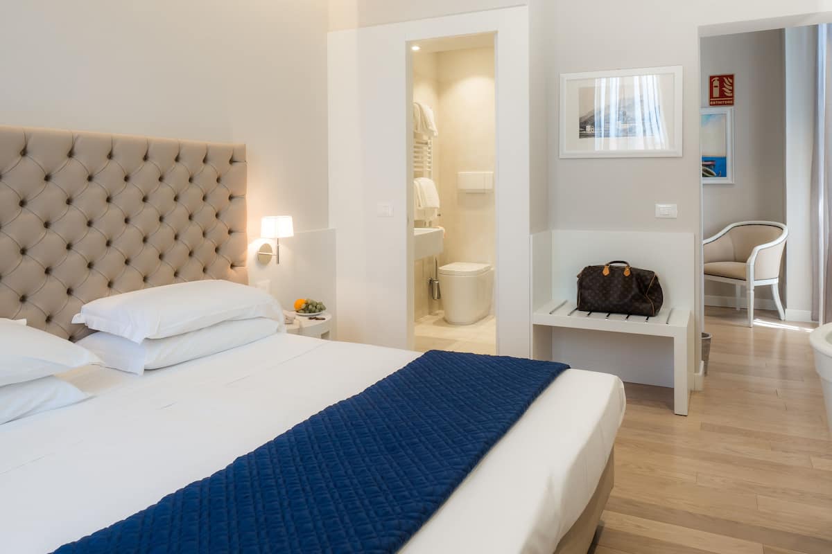 deluxe double or twin room, balcony, pool view | minibar, in-room safe, desk, iron/ironing board
