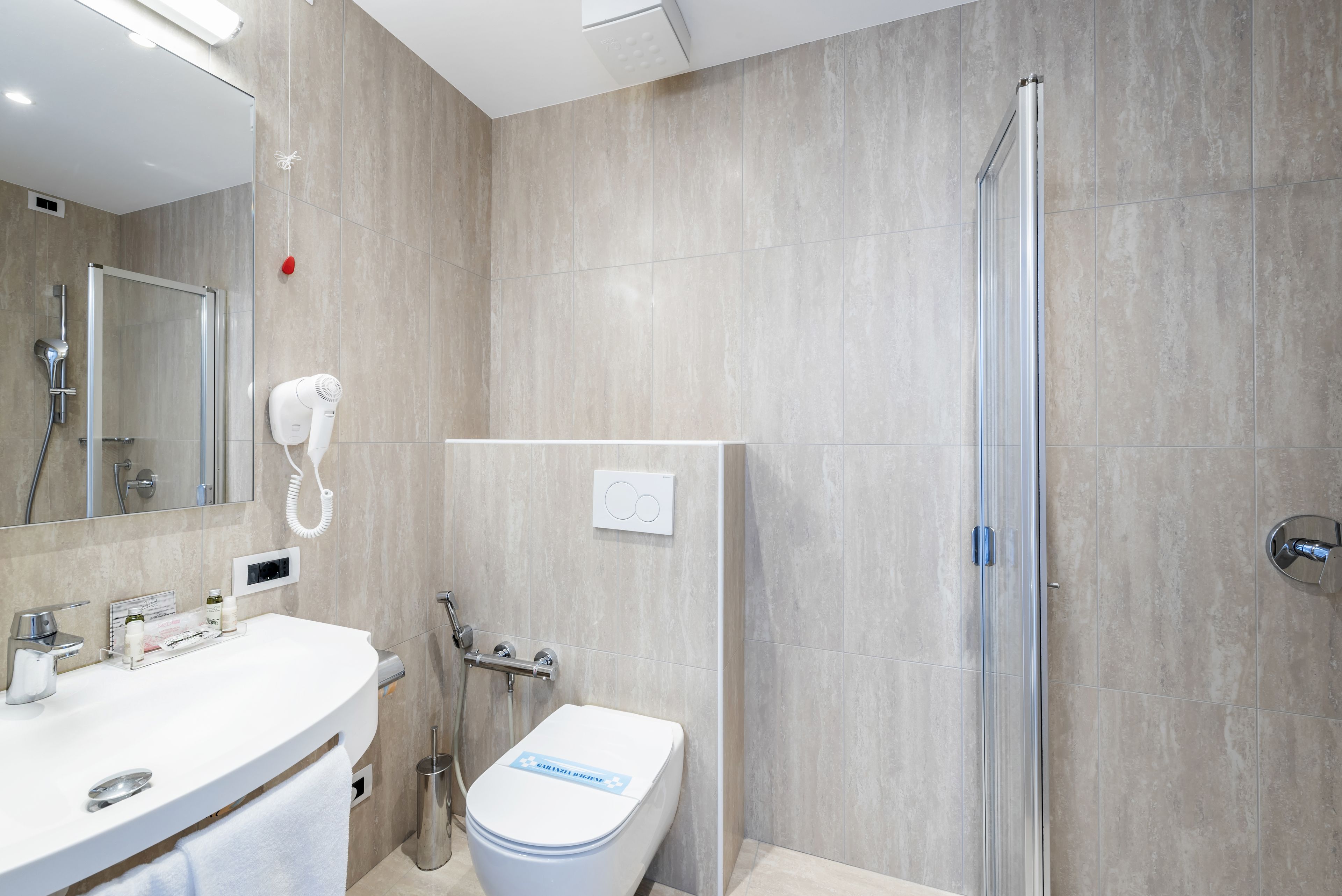 Une salle de bain moderne équipée d’une douche, de toilettes et d’un lavabo.