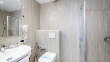 Une salle de bain moderne équipée d’une douche, de toilettes et d’un lavabo.
