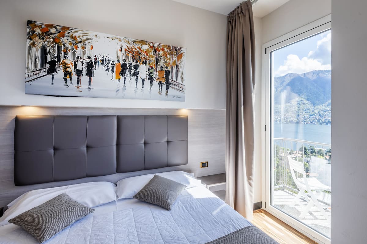 standard double room, balcony, lake view | minibar, in-room safe, desk, laptop workspace