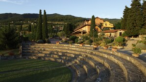 Un anfiteatro al aire libre con escalones de piedra y un espacio verde en el frente.
