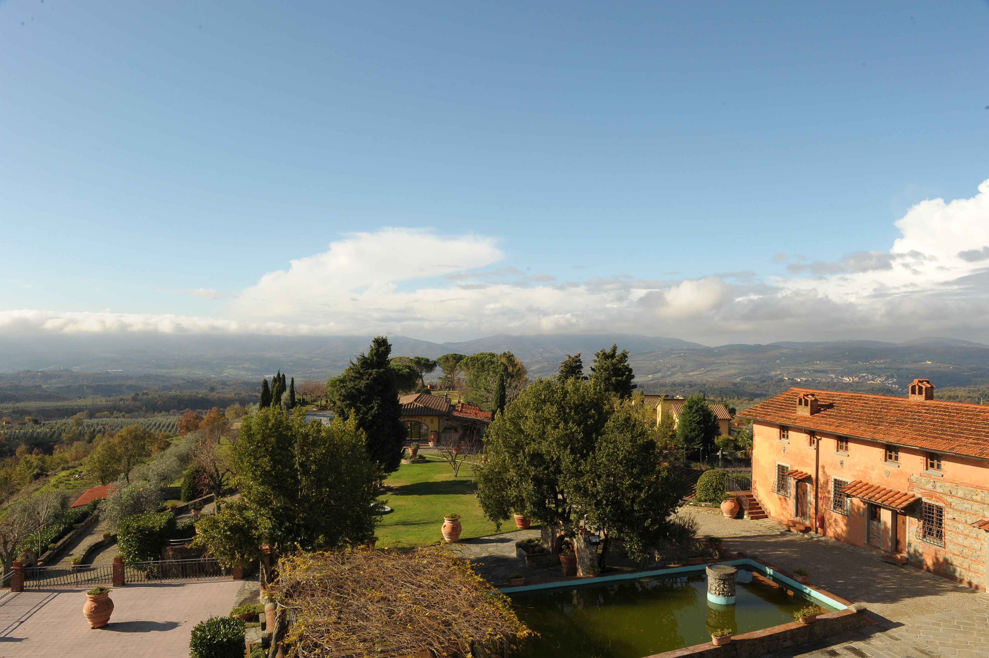 A courtyard with a pool, terraced garden, and traditional architecture.
