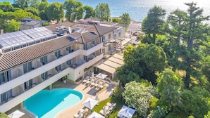 A multi-story hotel with a rooftop pool, a beachside location, and lush greenery. - Villa Rosa Hotel (Desenzano del Garda)