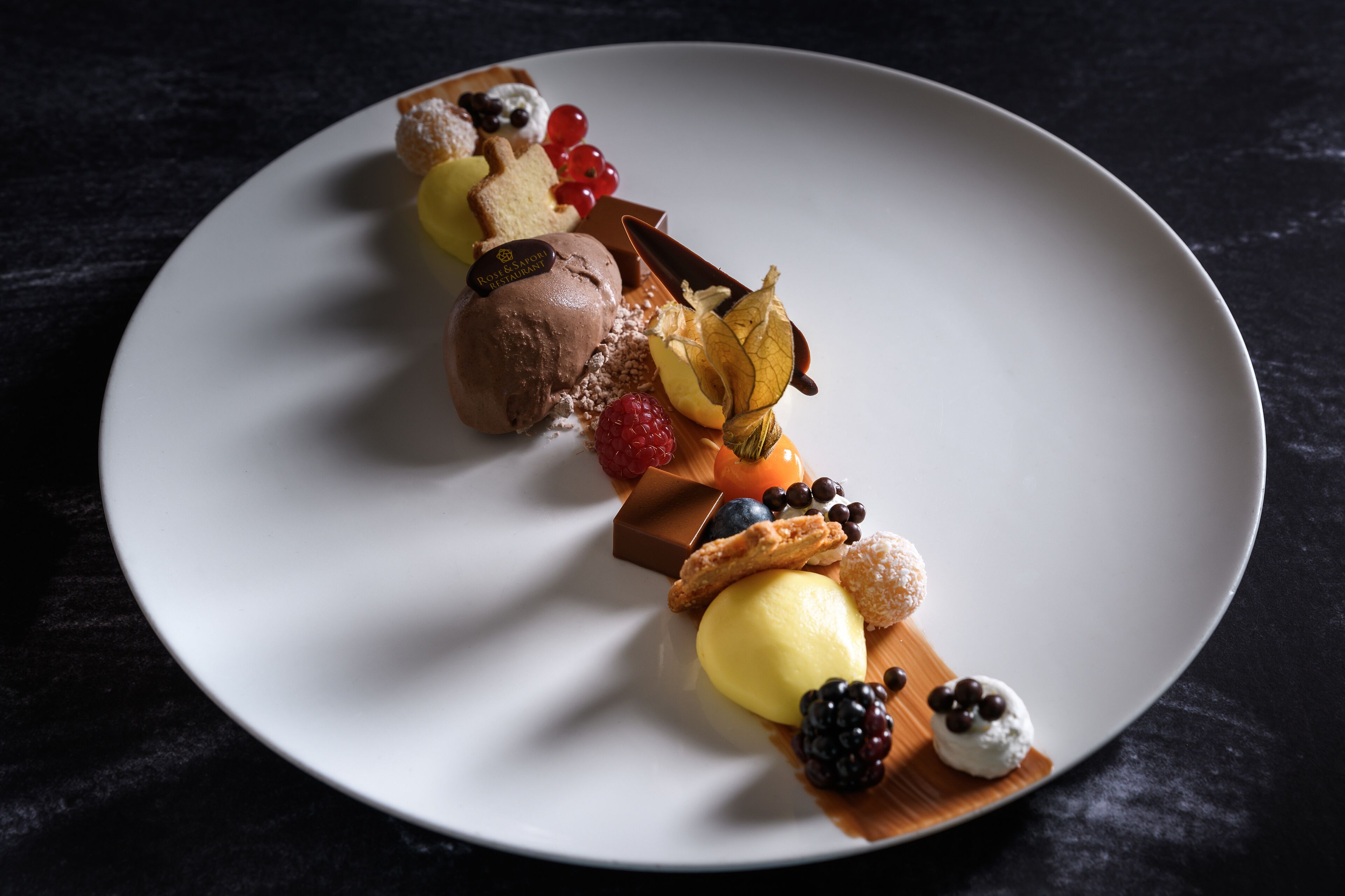 En desserttallerken med forskellige slik og frugter.