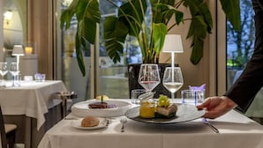 A dining table with plates of food, wine glasses, and a candle. - Villa Rosa Hotel (Desenzano del Garda)