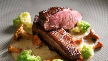 A plate of food with a piece of meat and vegetables.
