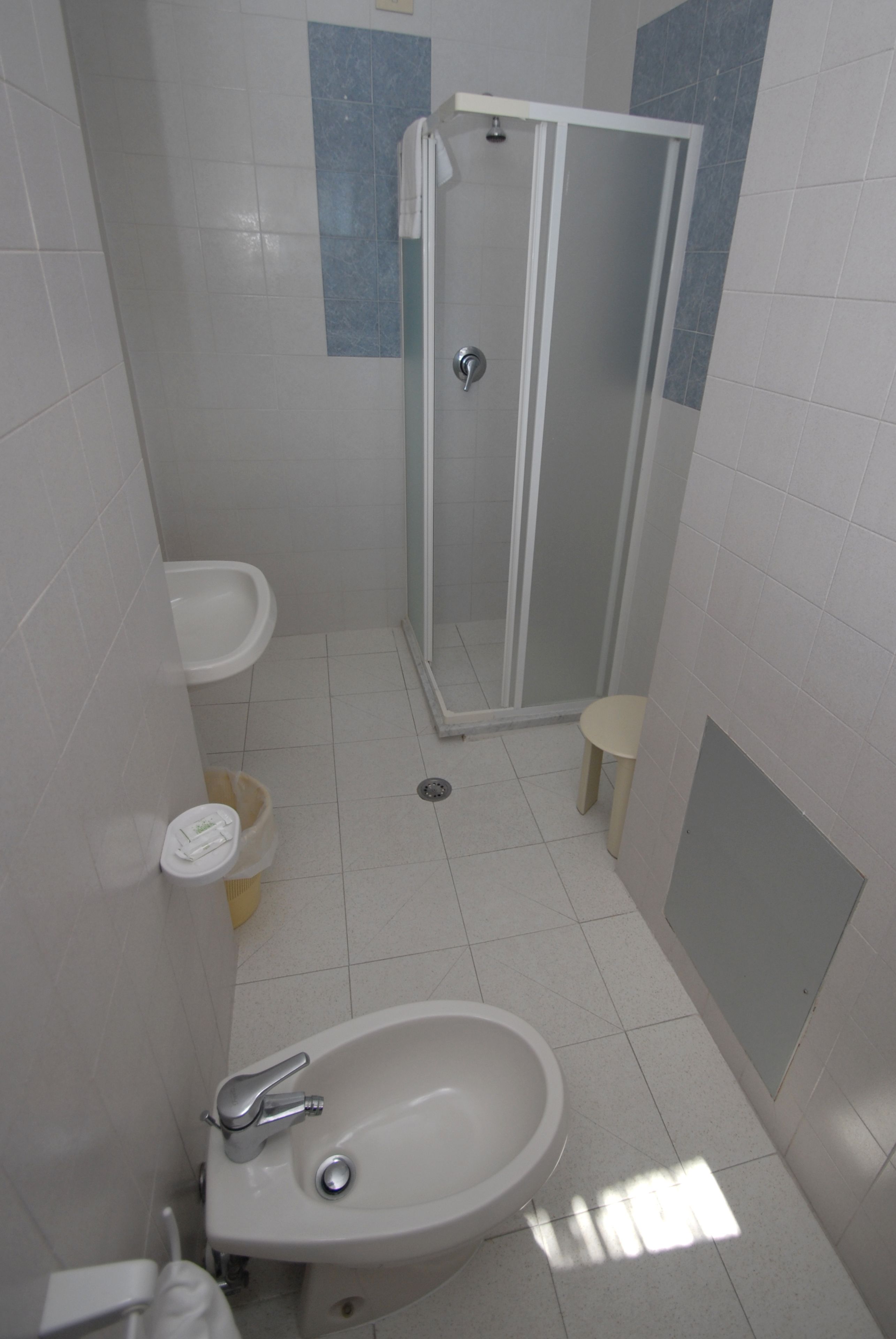 A bathroom with a shower, sink, and toilet.