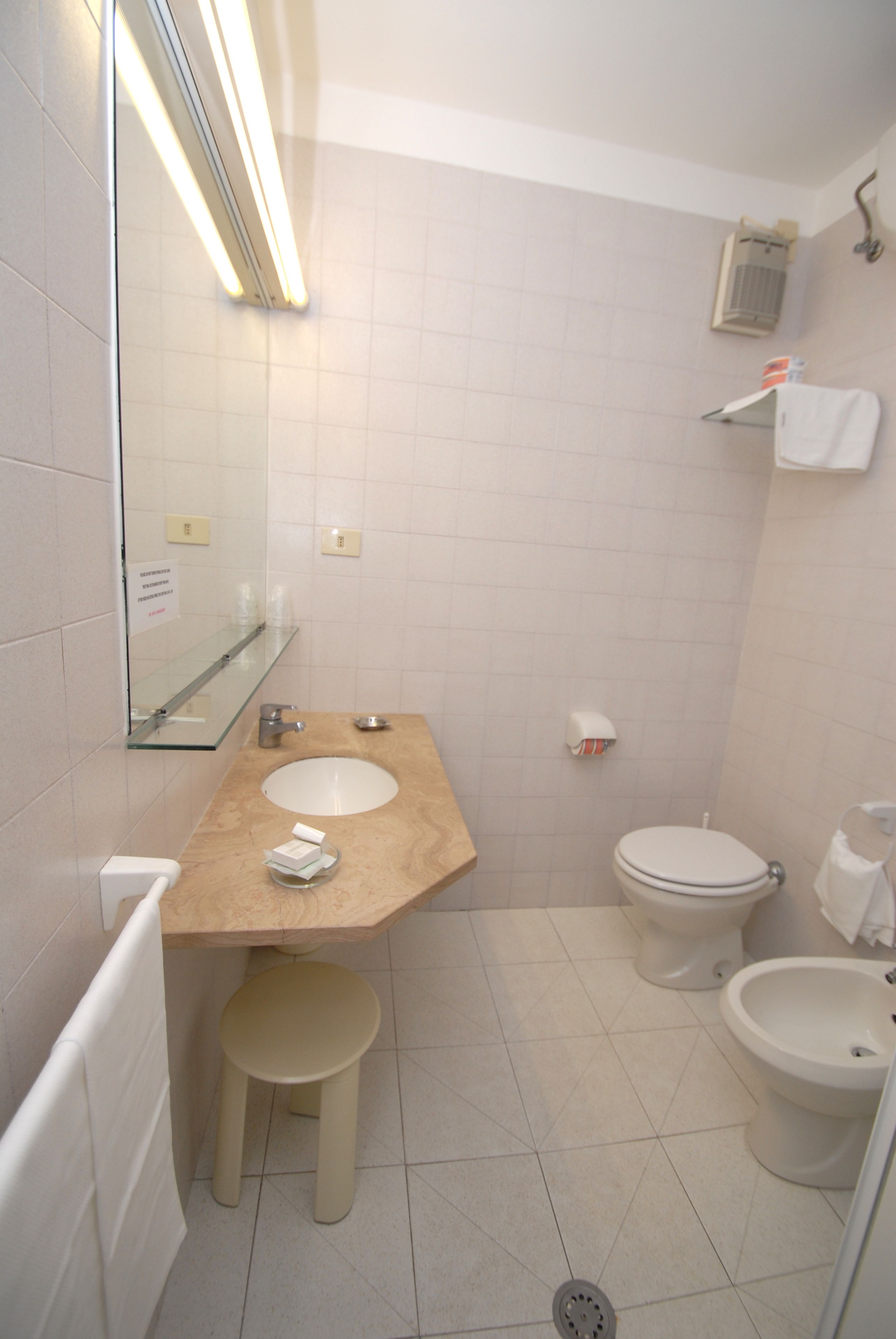 Ein Badezimmer mit Waschbecken, Toilette, Bidet und Spiegel.