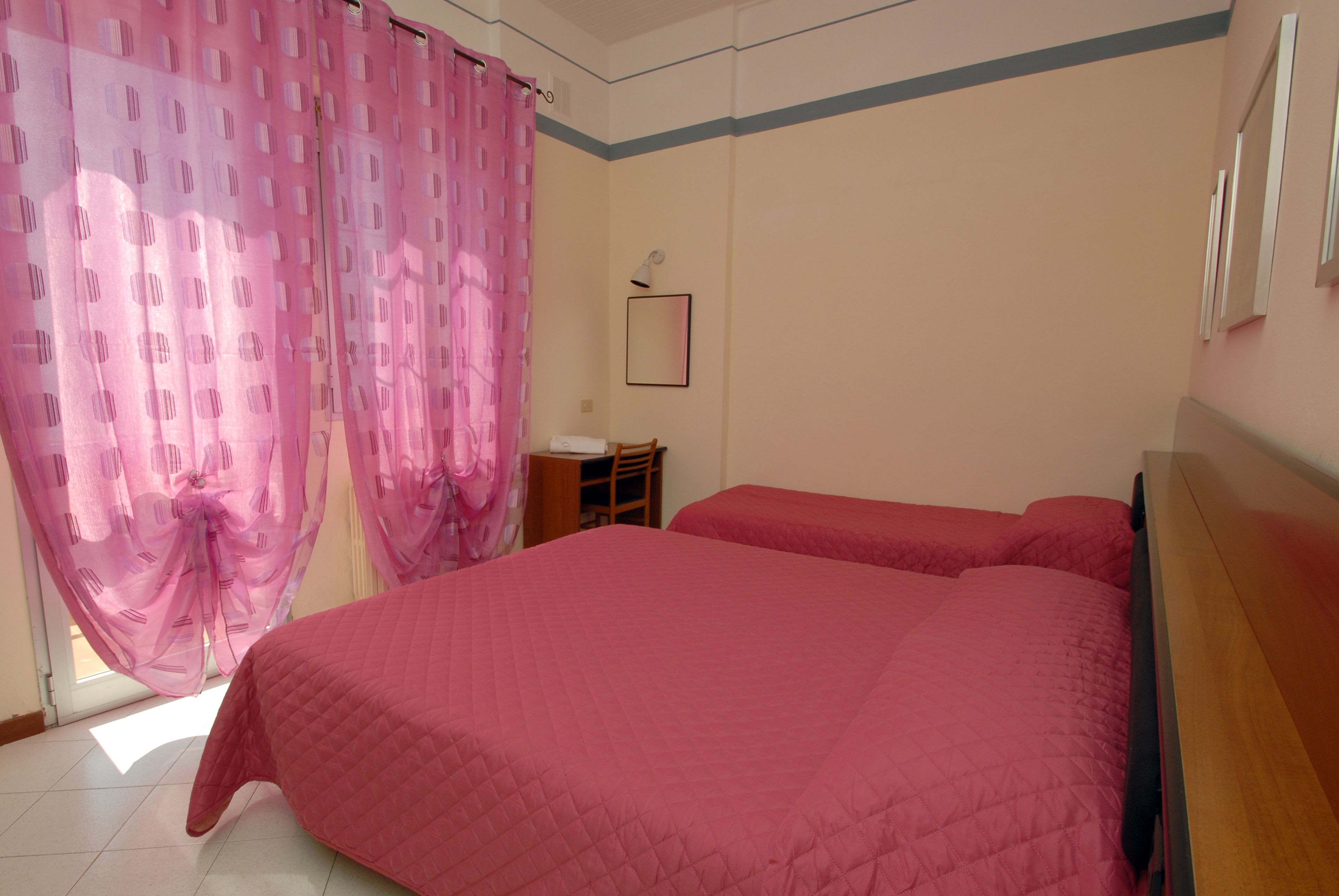 Un dormitorio con una cama grande, un escritorio y una silla.