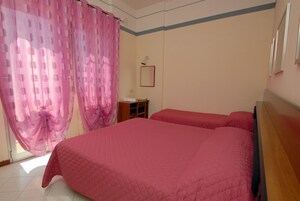 Un dormitorio con una cama grande, un escritorio y una silla.