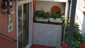 A hotel entrance with a glass door, a red carpet, and potted plants. - Hotel Ristorante Baia del Sorriso (Rosignano Marittimo)