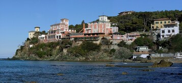 Un pueblo costero con edificios en una colina con vistas al mar.