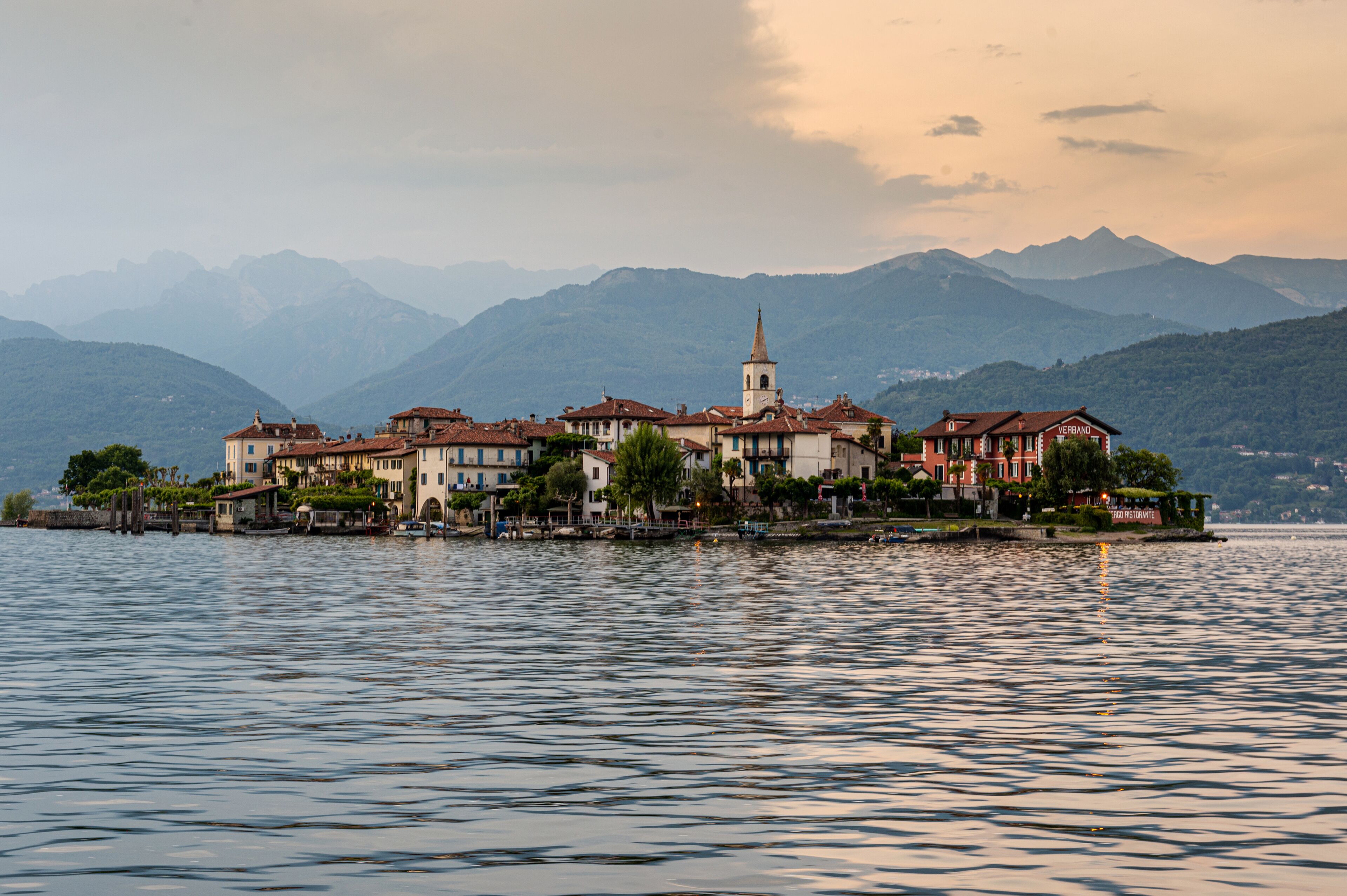 A waterfront property with multiple buildings, a prominent church tower, and a restaurant.