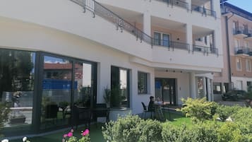 Un edificio residencial de varios pisos con balcones, ventanas amplias y zonas de estar al aire libre.