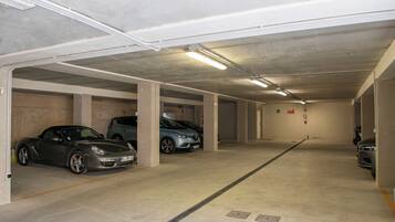Eine mehrgeschossige Tiefgarage mit Betonpfeilern und Neonbeleuchtung.