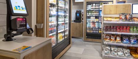 A self-service beverage station with refrigerated drinks, a coffee machine, and snack dispensers.