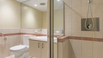 Une salle de bain avec des toilettes, un lavabo et une douche.