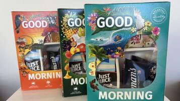 Three Just Juice Morning boxes with tropical and oceanic designs.
