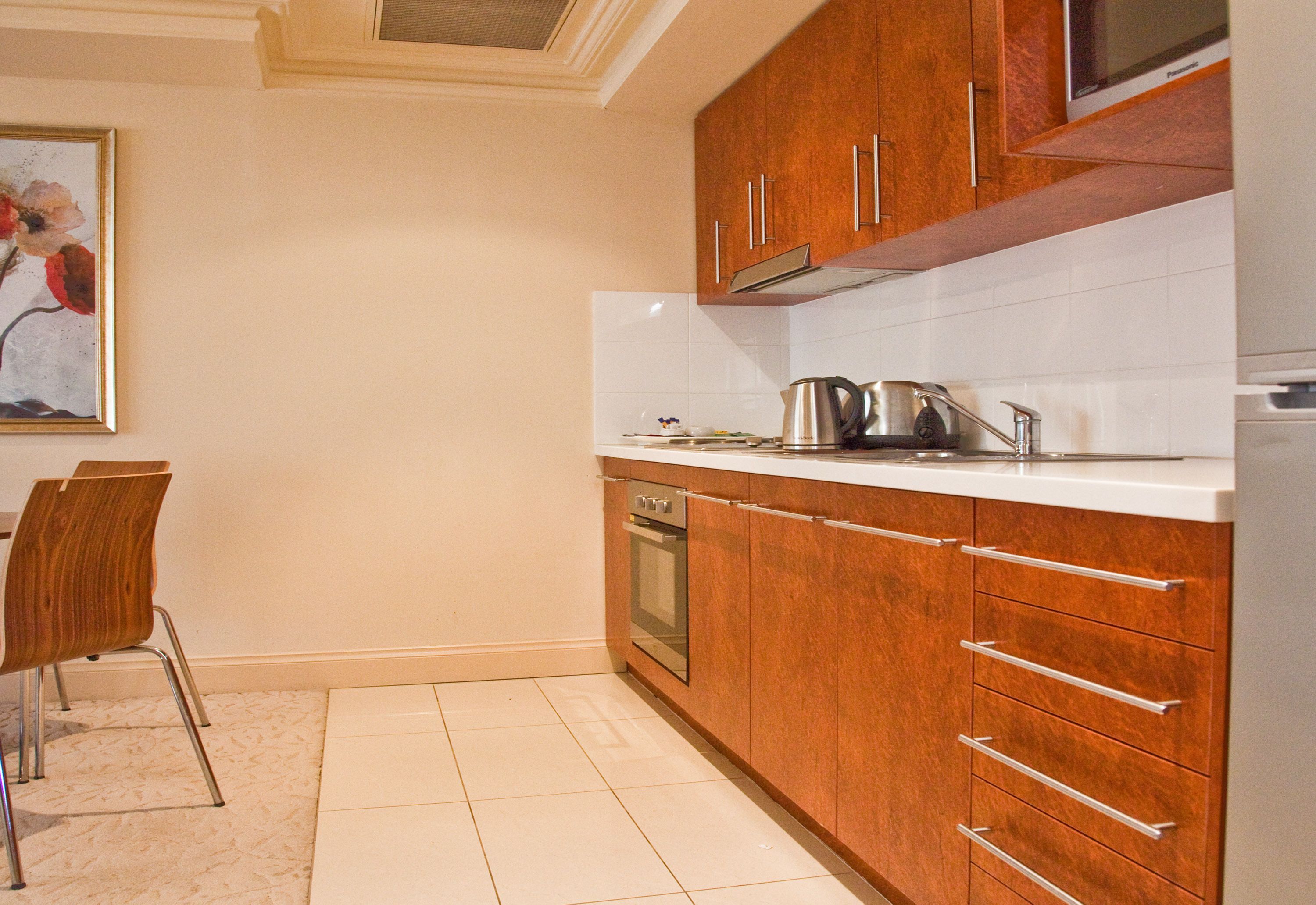 Una cocina con armarios de madera, microondas y fregadero.
