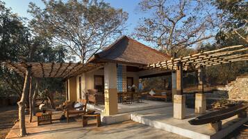 Una casa tradicional japonesa con tejado de tejas, muebles de madera y un sendero de piedra que lleva a la entrada.