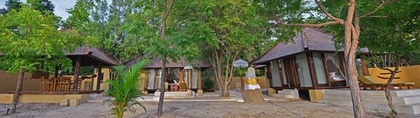 A resort with multiple bungalow-style accommodations, each with a private entrance and a small porch area.