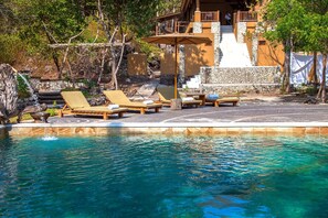 Alberca al aire libre y camastros