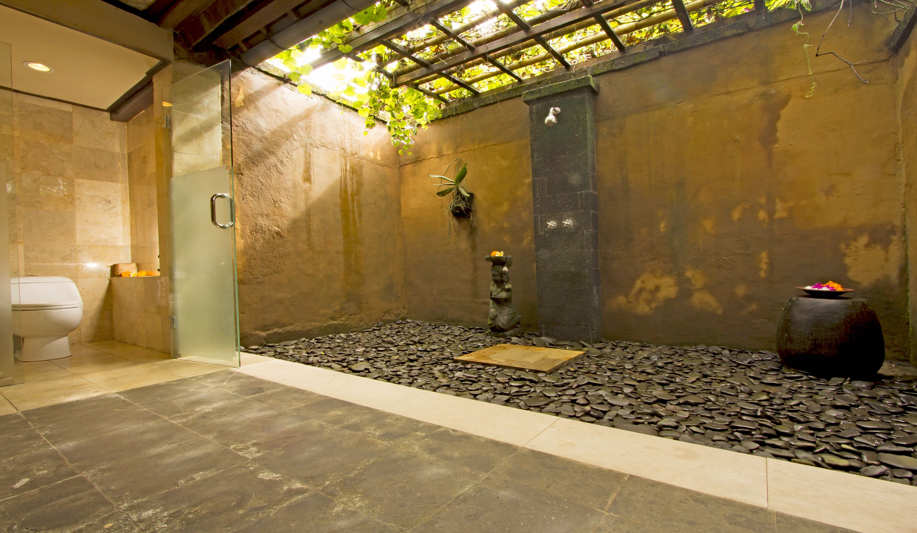Un espace spa doté d’un sol en pierre, d’une petite cascade et d’un pilier décoratif en pierre.