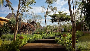 A garden pathway with lush greenery and a clear sky. - WakaGangga (Tabanan)